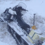 поломанный снегоход в cнегу