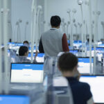 Ученики сидят за компьютеров и сдают тест