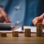 Бір адам калькуляторда тиындарды санап жатыр